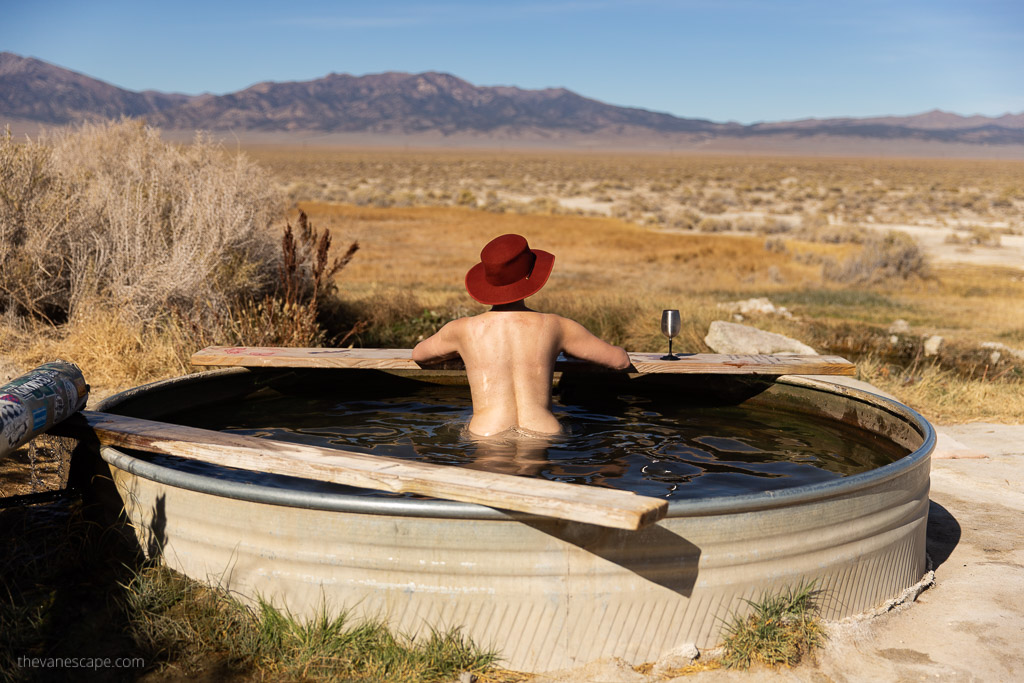 Agnes Stabinsa, the author, is relax in spencer hot springs in nevada where clothing is optional. She has a glass of wine and looking at the mountains.