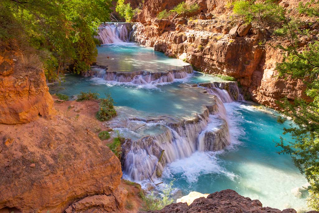 Blue cascade water among orange rocks at Beaver Falls in Havasupai Grand Canyon.