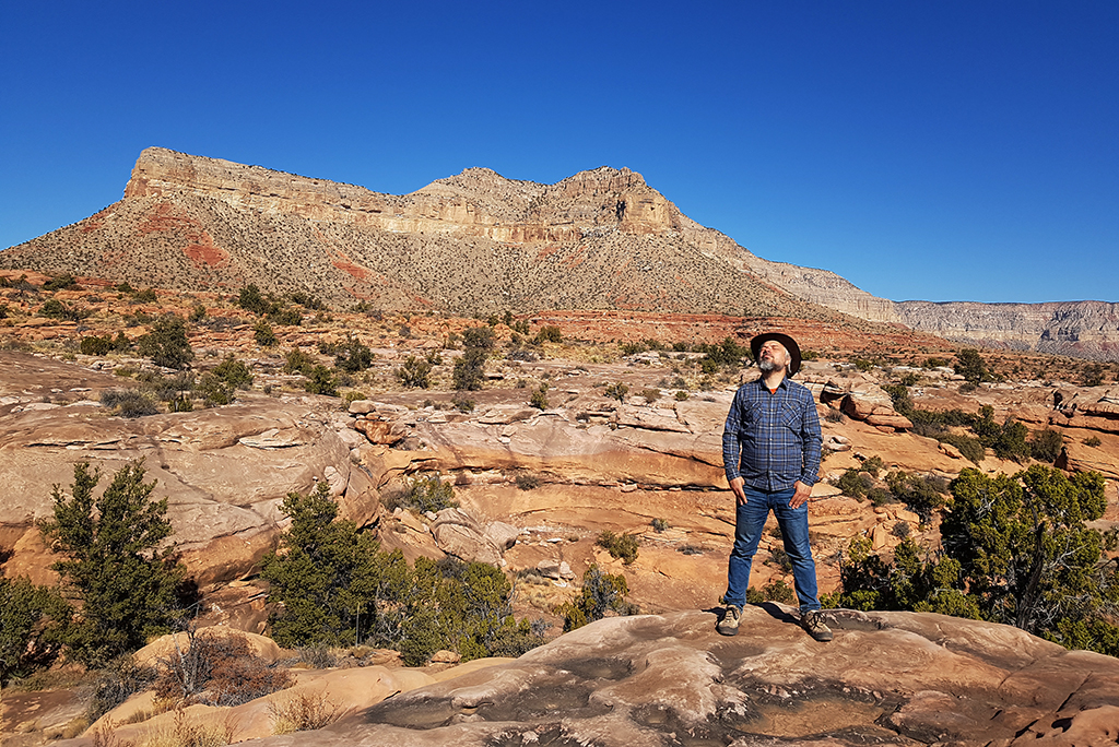 Chris Labanoski, my partner and co-founder of The Van Escape blod is standing with a cowboy hat at Tuweep Campground