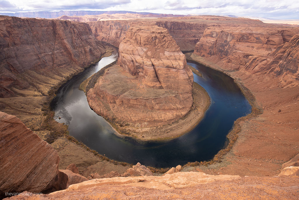 the end of the Horseshoe bend hike with stunning view of the bend, blue river around it and oragne cliff walls. 