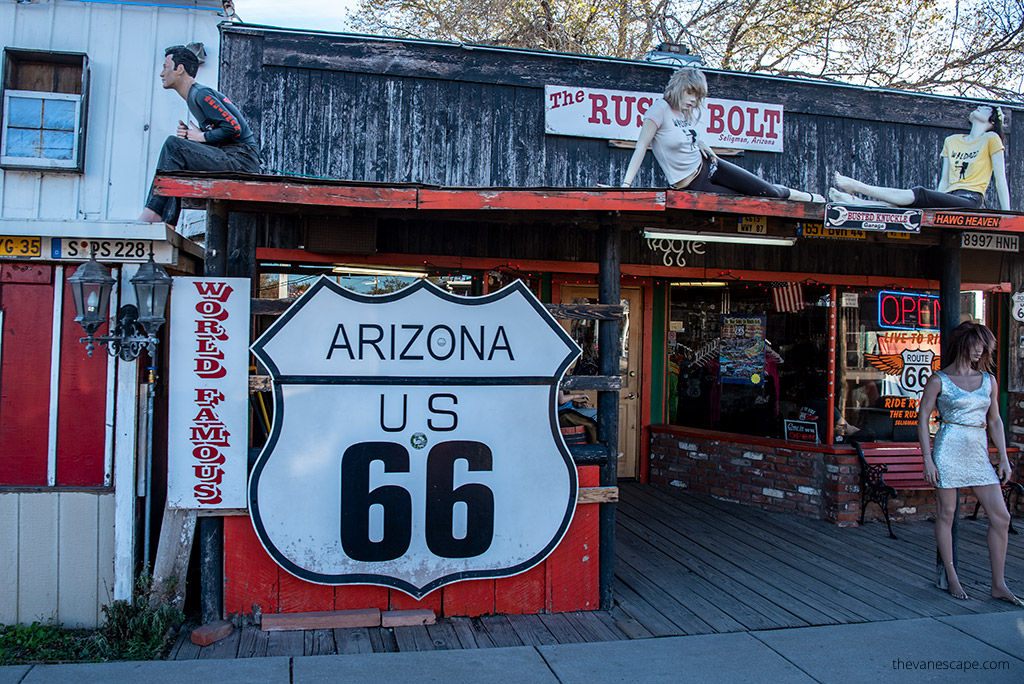 Route 66 Arizona: A wooden colorful building with standing mannequins and the Route 66 sign.