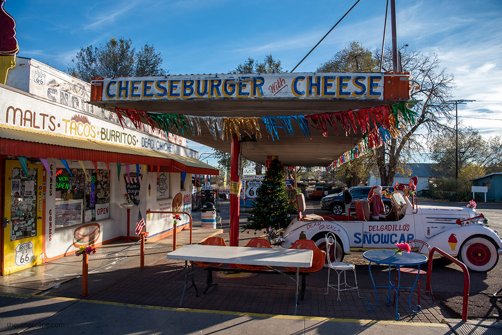 old restaurant on route 66 in arizona with with old car at the front of the entrance and sign: cheesburger and cheese.