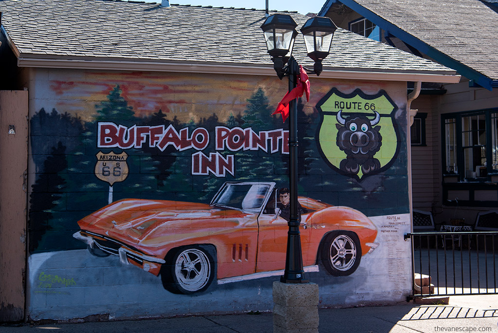 Williams: mural on the wall with orange old Cadillac and inscription: Buffalo Pointe Inn on route 66.