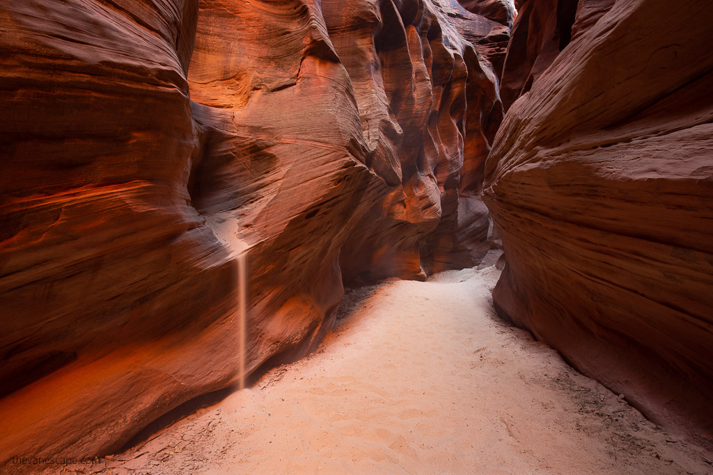 sand flowing from the red rock walls of Buckskin Gulch slot canyon