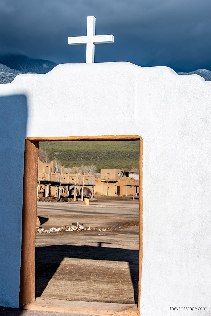 white entrance with white cross to the Taos Pueblo Church