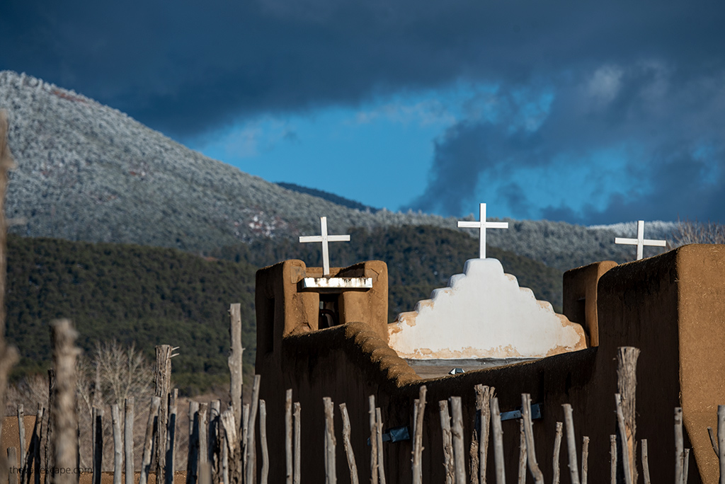 Taos Pueblo Church with mountains in the backdrop.