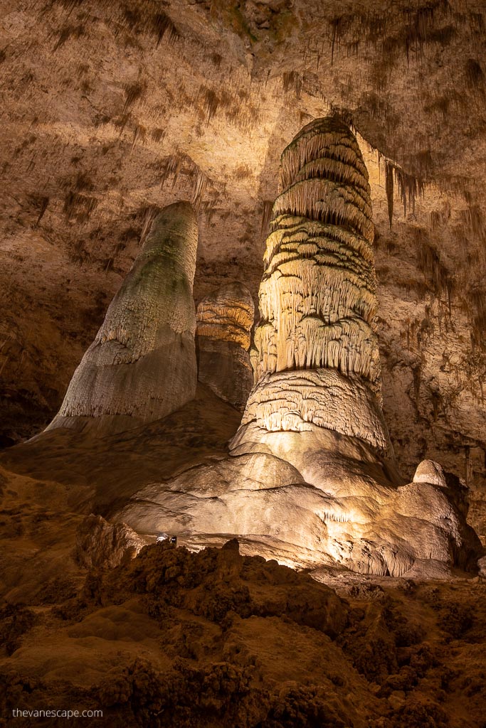 Stalactites and stalagmites in the softly lit cave.