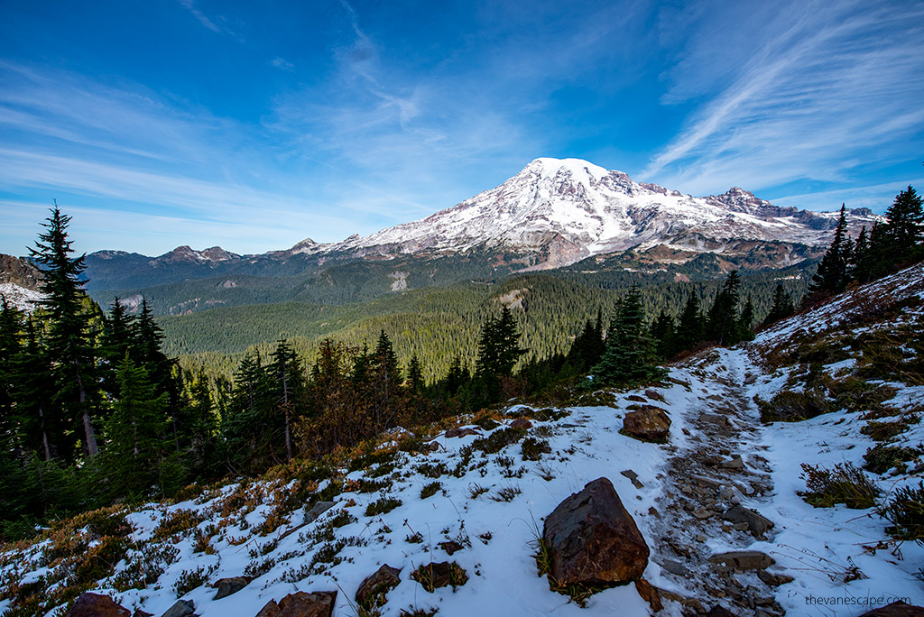 hiking trail covered by snow with the view of Mount Rainier in the backdrop.