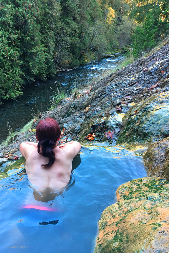 Agnes is soaking in Umpqua Hot Springs with the forest view.