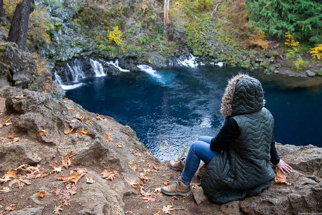 Agnes Stabinska, the author, is sitting on the rocks and admiring the blue water and view of Tamolitch Blue Pool.