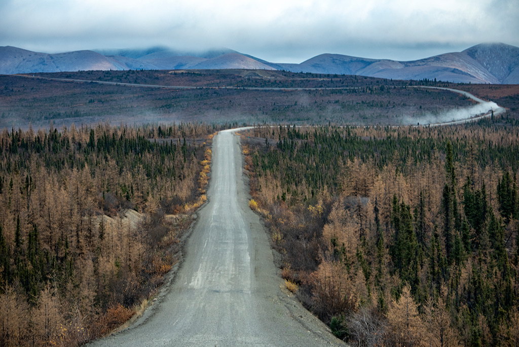 Road Trip Packing List: stunning gravel road and mountain view in Canada.