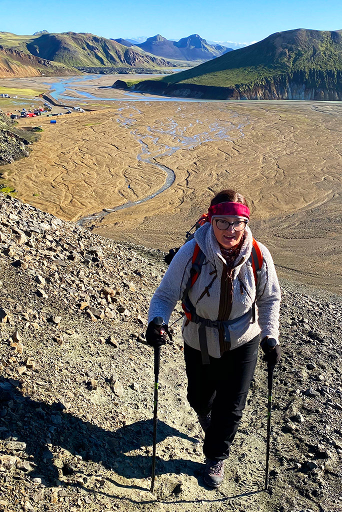 Agnes Stabinska, the author is hiking in Iceland with camping and mountains in the backdrop.