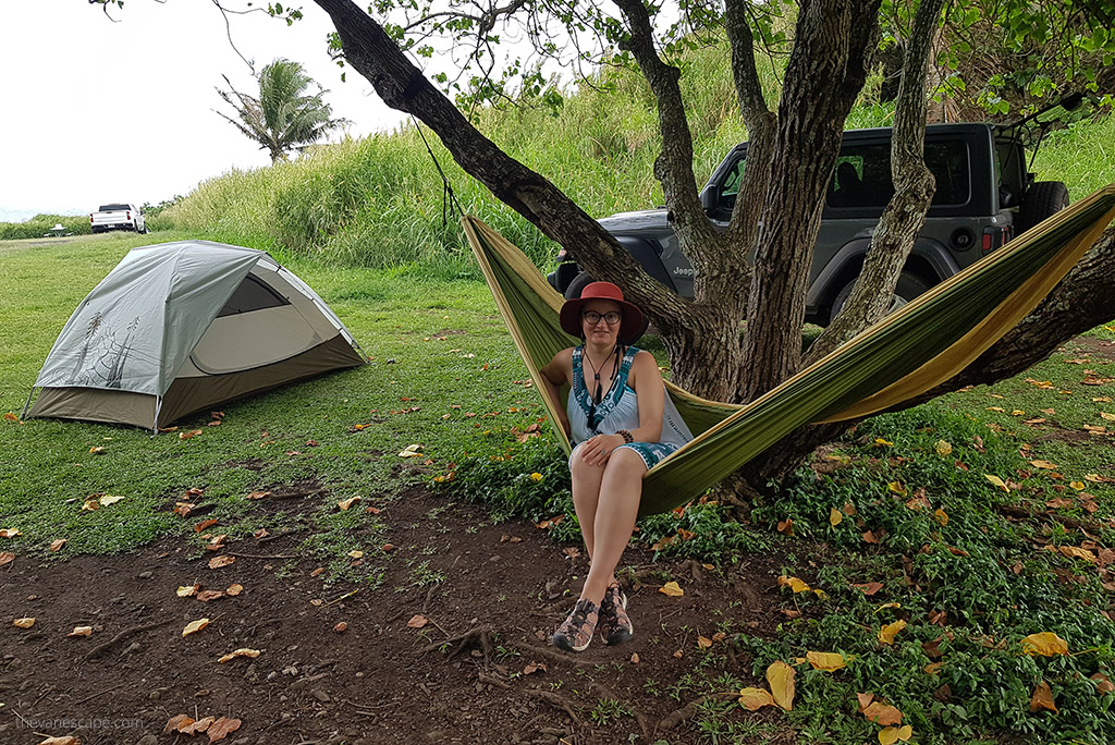 Agnes Stabinska, the author and co-founder of The Van Escape blog on a Car Camping: she is sitting in a hammock next to her tent and next to a jeep wranagler.