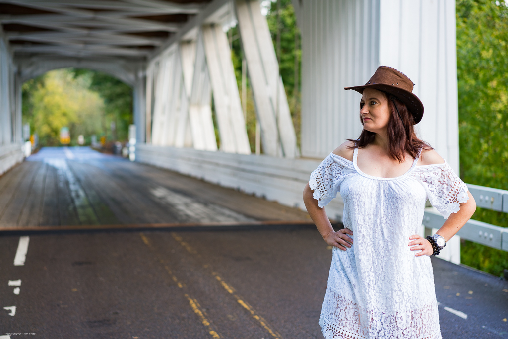 Agnes Stabinska, the author, with cowboy hat and white dress standing on Oregon Covered Bridge.