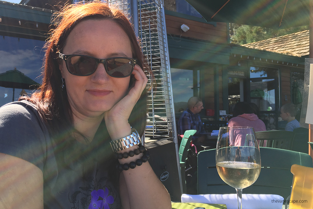 Agnes Stabinska, the author is sitting in a restaurant in a lake tahoe view and she is drinking a white wine.