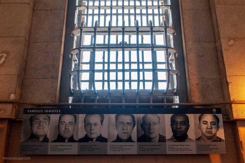 A large barred prison window and under it black and white photos with portraits of the most famous prisoners.