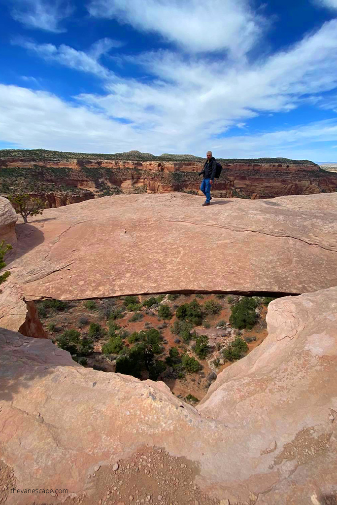 Chris Labanowski, co-owner of the Van Escape Blod, is standing on the orange arch at Rattlesnake Arches Trail