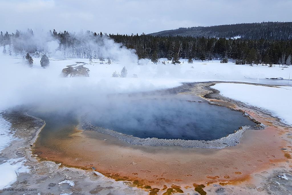 steaming colorful geysers in the winter scenery of Yellowstone.