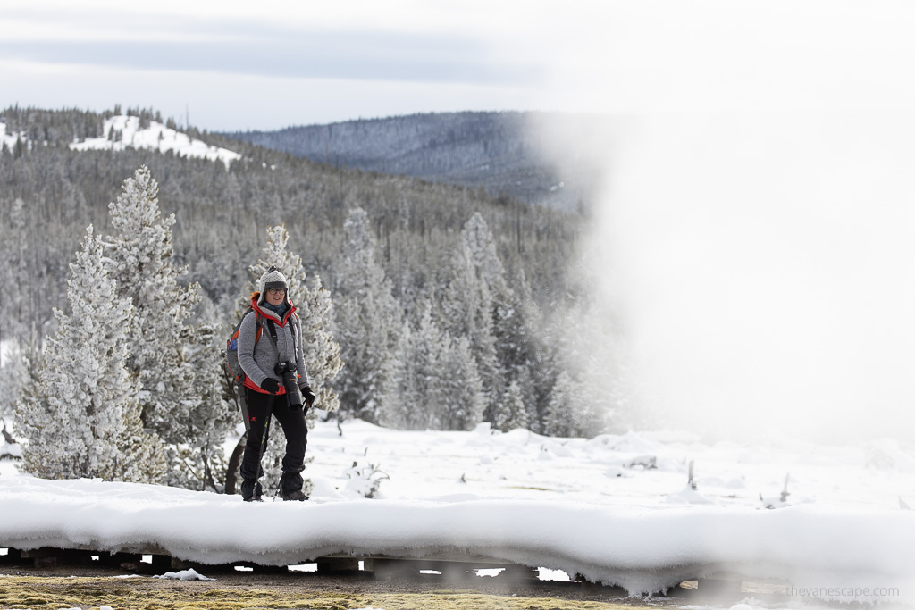 Agnes hiking along geyser during frosty winter in Yellowstone.