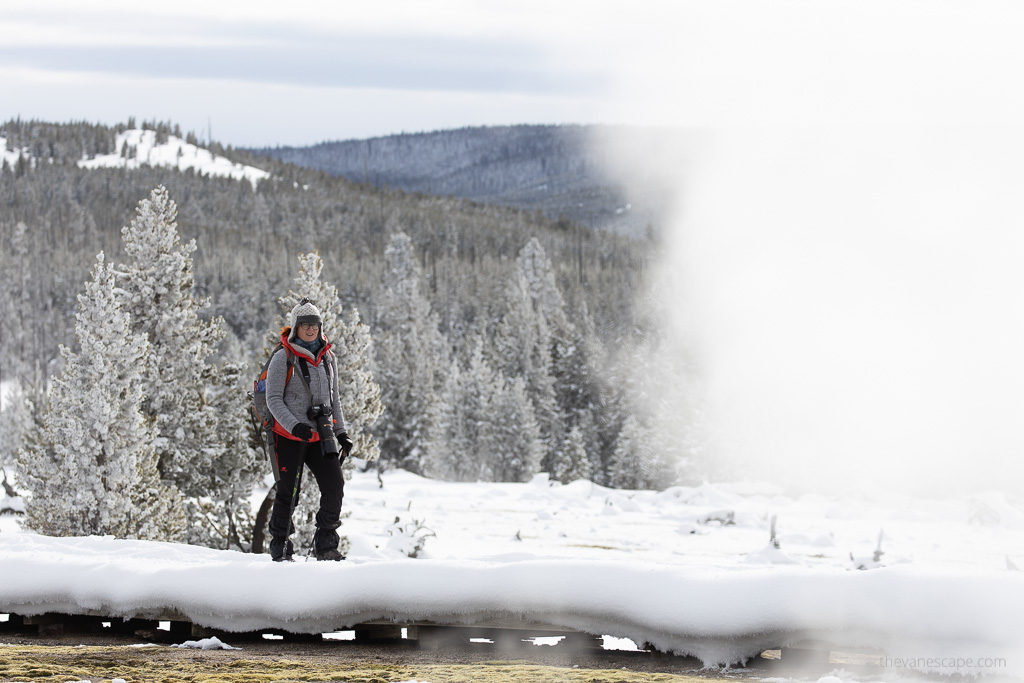 Agnes Stabinska, the author and co-founder of the Van Escape blog, is hiking along geyser during frosty winter in Yellowstone.