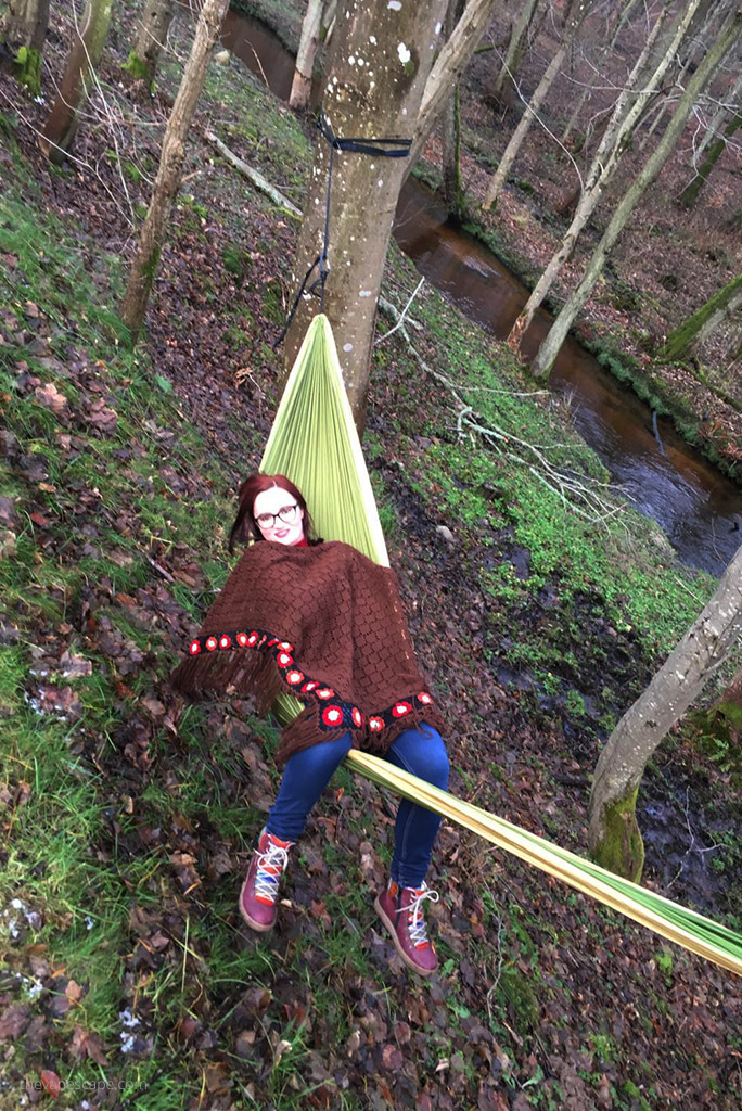 Agnes in Backpacking Hammock between trees next to the stream.