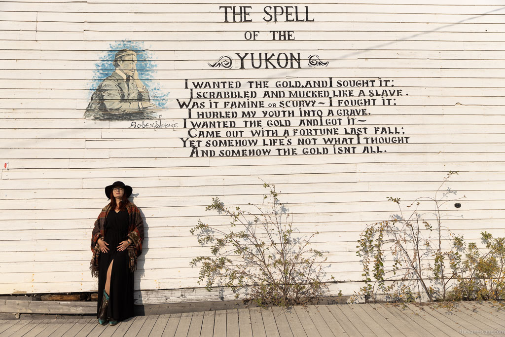 Agnes Stabinska, the author, next to the wall with the mural with inscription: the spell of the Yukon Dawson City