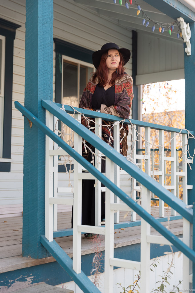 Agnes Stabinska, the author and co-owner of the Van Escape blog, is standing on the wooden porch in Dawson City Yukon