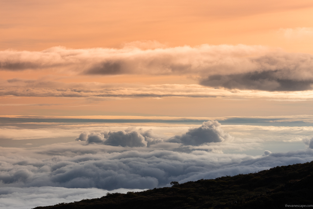 Sunset above the clouds over the hills.