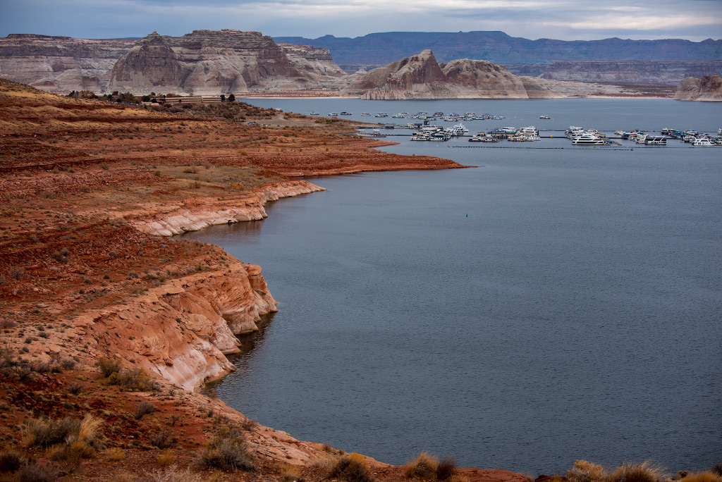 the view of boats on the Lak Powell and stunning orange rock formations around it.