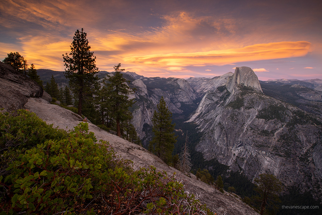 stunning sunset in yosemite with orange sky and spectacular clouds above mountains.