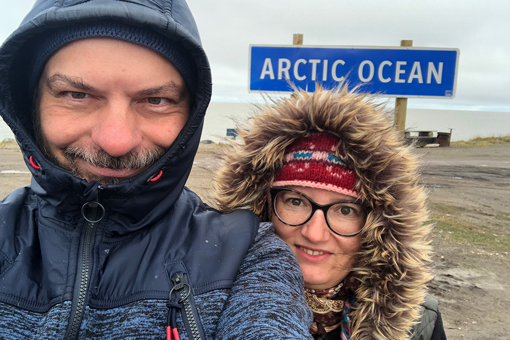 Things to do in Tuktoyaktuk - Agnes Stabinska, the author, and her partner Chris taking picture with the Arctic Ocean sign.