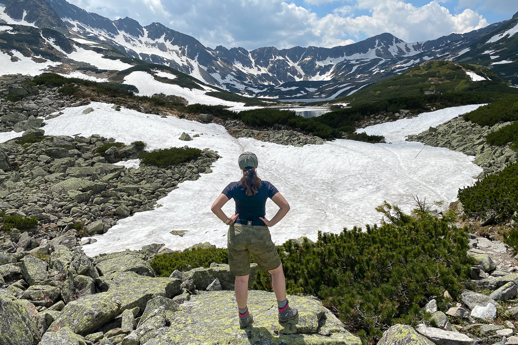 Agnes Stabinska, the author and cofounder of The Van Escape blog, on a day hike in Tatra mountains with a lake, snow and peaks view.