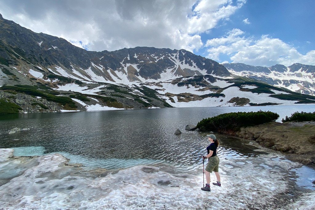 Agnes Stabinska in KUHL SPLASH 11" Hiking Shorts for Women on the hiking trail in the mountains. She is on the snow and ice next to lake and admiring mountain and glaciers.