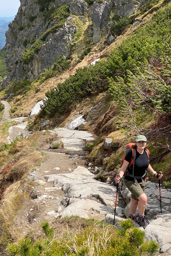 Agnes in KUHL SPLASH 11" shorts and hiking boots and with trekking poles on the hiking trail.