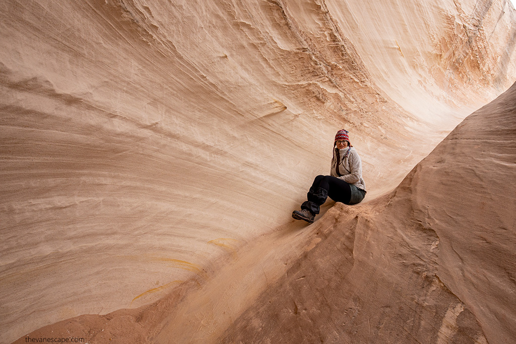 Agnes Stabinska, the author and co-owner of The Van Escape blog, is sitting in KUHL Flight Jacket on the rock formations on hiking trail.