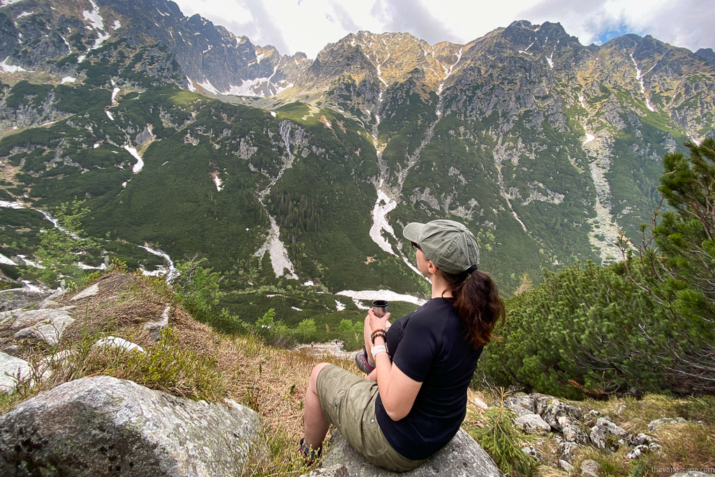 Agnes Stabinska, the author, is sitting on the rock with the mountain view. She is wearing KUHL SPLASH 11" shorts and admiring the view.