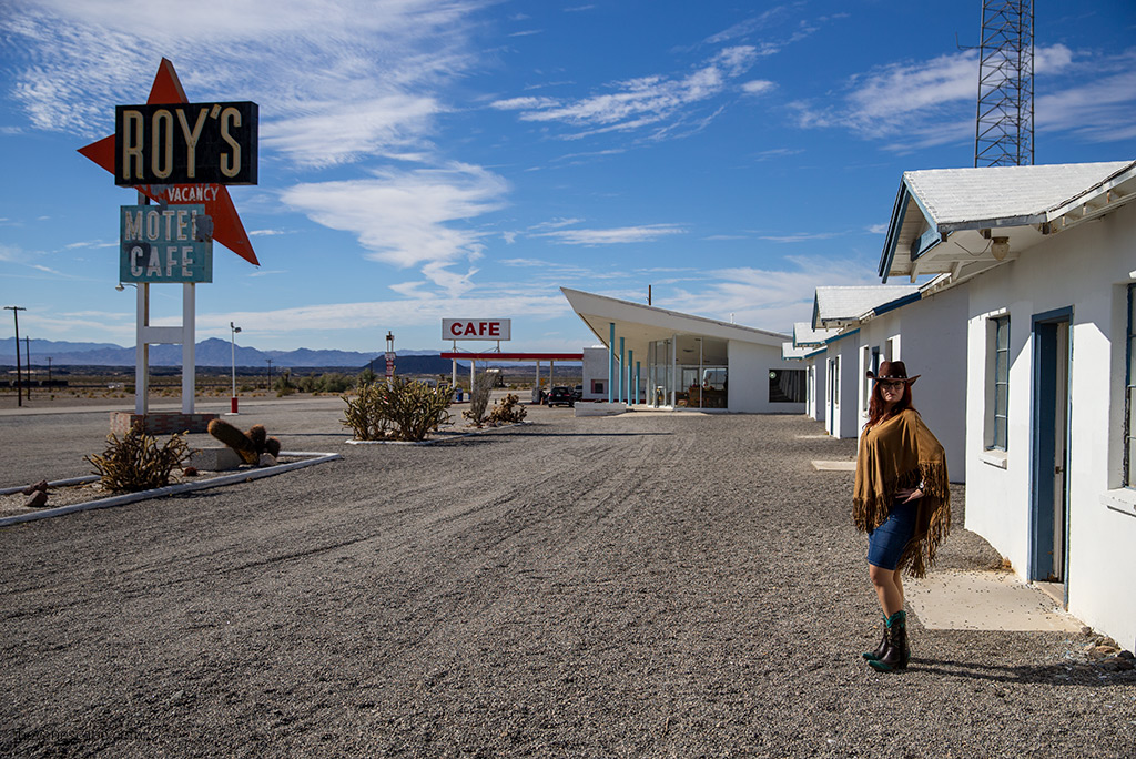 Agnes Stabinska, the author, in cowboy hat and boots next to the entrance to Roy's Motel