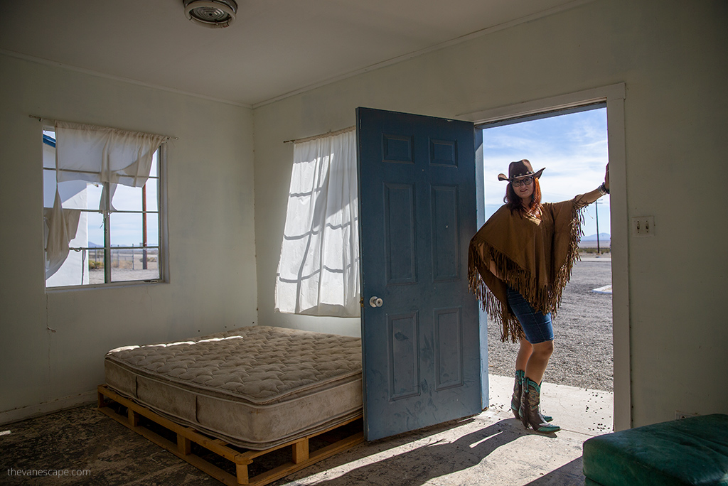 Agnes Stabinska, the author, with cowboy hat and boots inside the abandoned Roy's Motel in Amboy