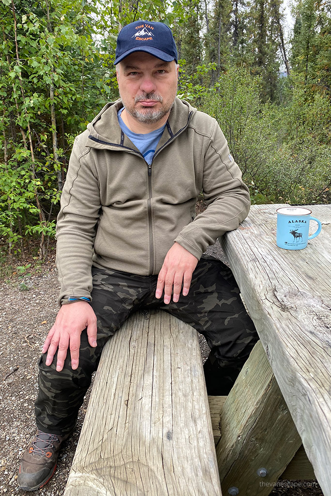 Chris sitting at the picnic table in KUHL SILENCR ROGUE KARGO PANT