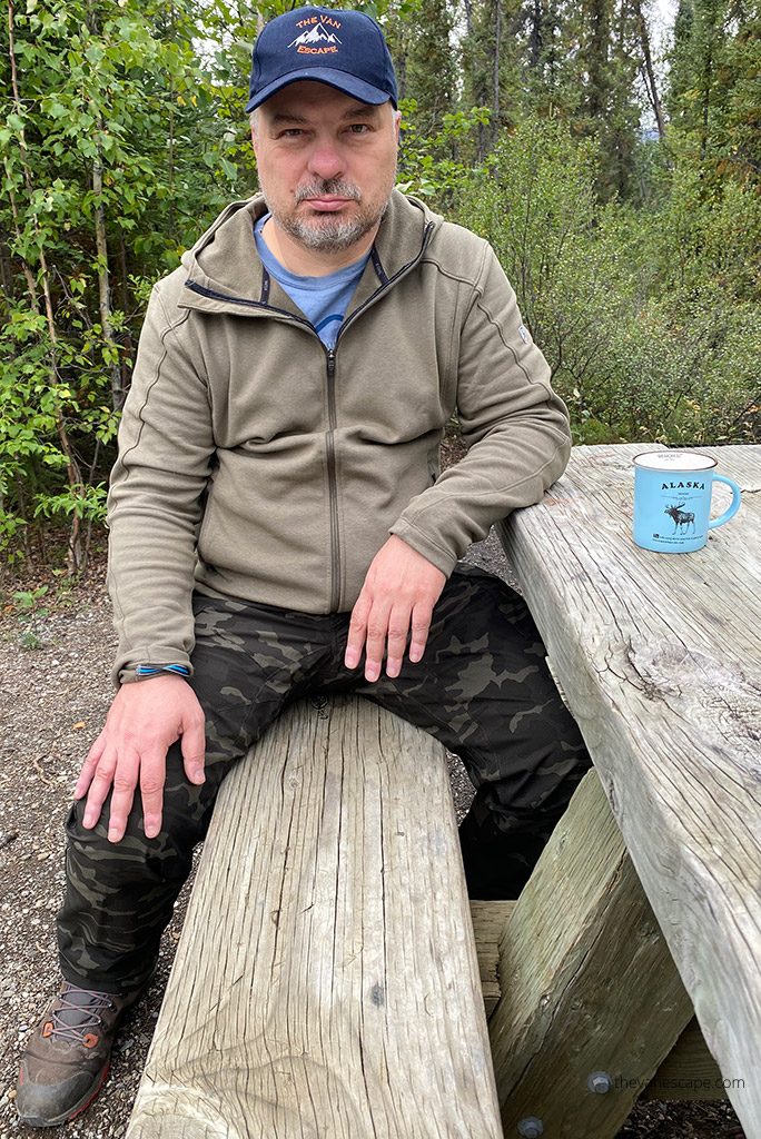 Chris Labanowski is sitting in KUHL SPEKTER Full Zip Hoody at the picnic table and drinking a coffee.