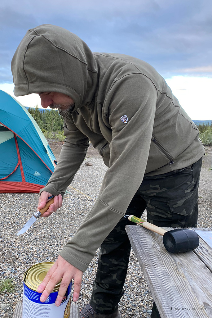 Chris Labanowski in hoodie by Kuhl on Alaska camping, next to tent.