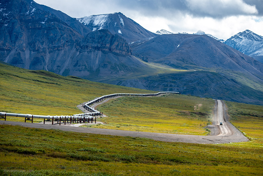 Dalton Highway Alaska - view of the mountains, gravel road and pipeline system.