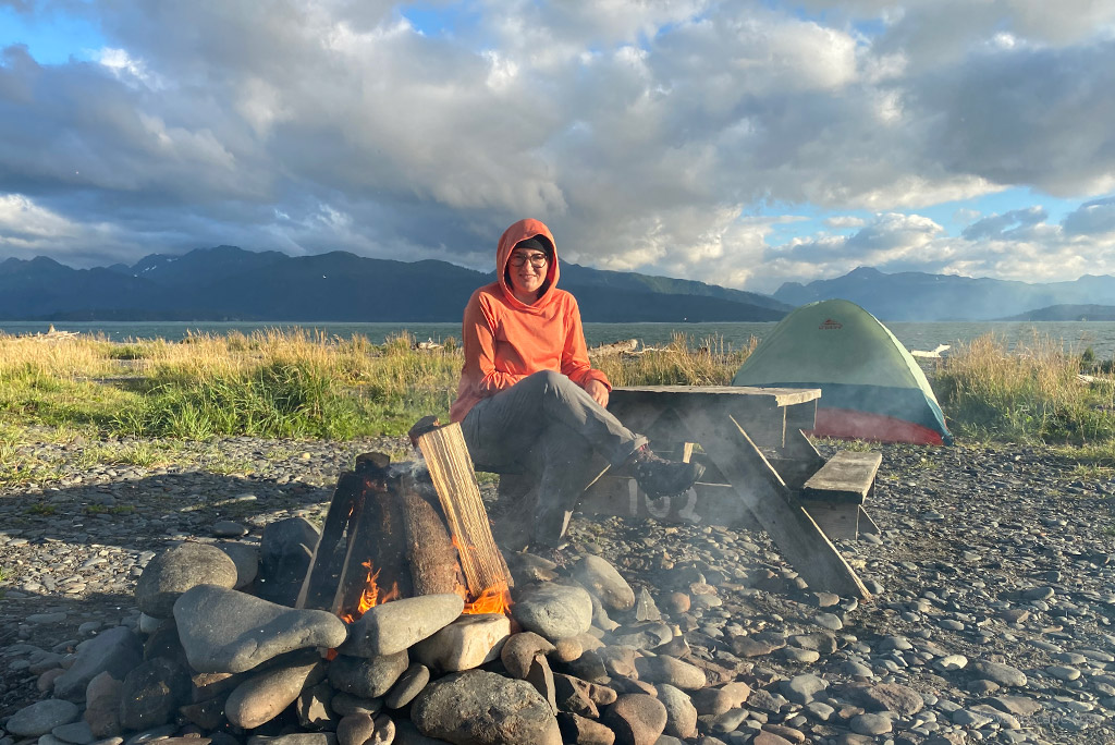 Agnes Stabinska, the author, is sitting at the campsite in KUHL FREEFLEX ROLL-UP Pants.