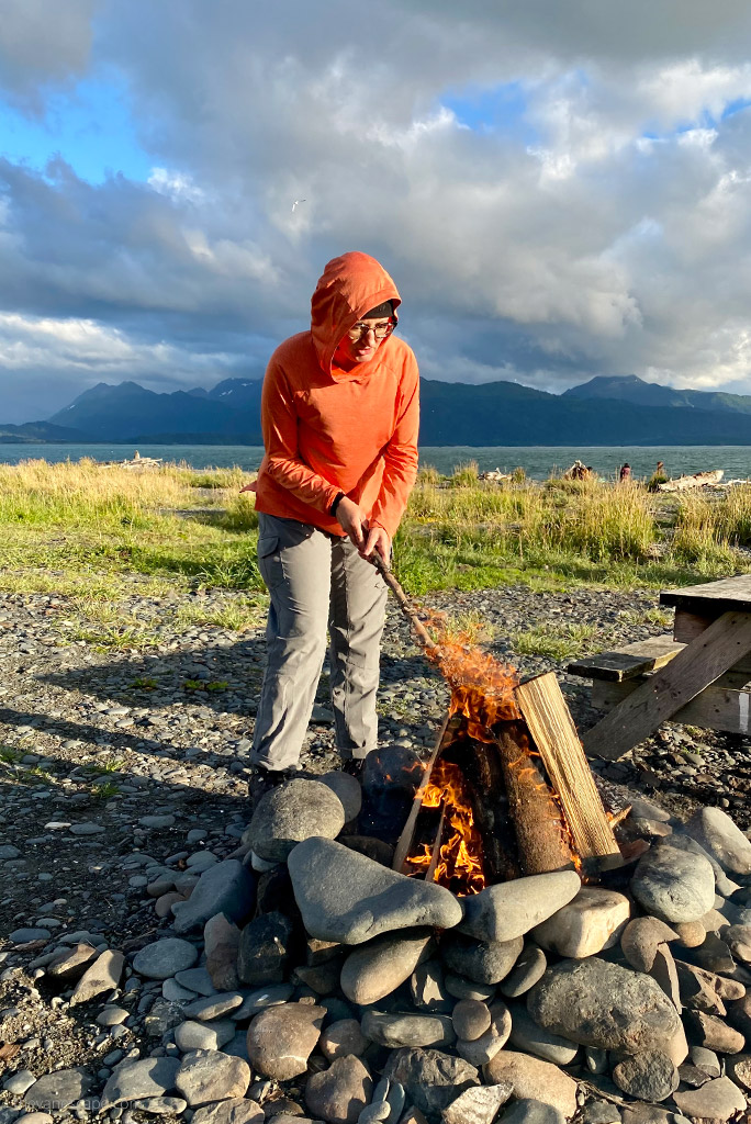 Agnes Stabinska, the author, is wearing KUHL FREEFLEX ROLL-UP Pantsand she is at the campsite next to campfire with the sea view.