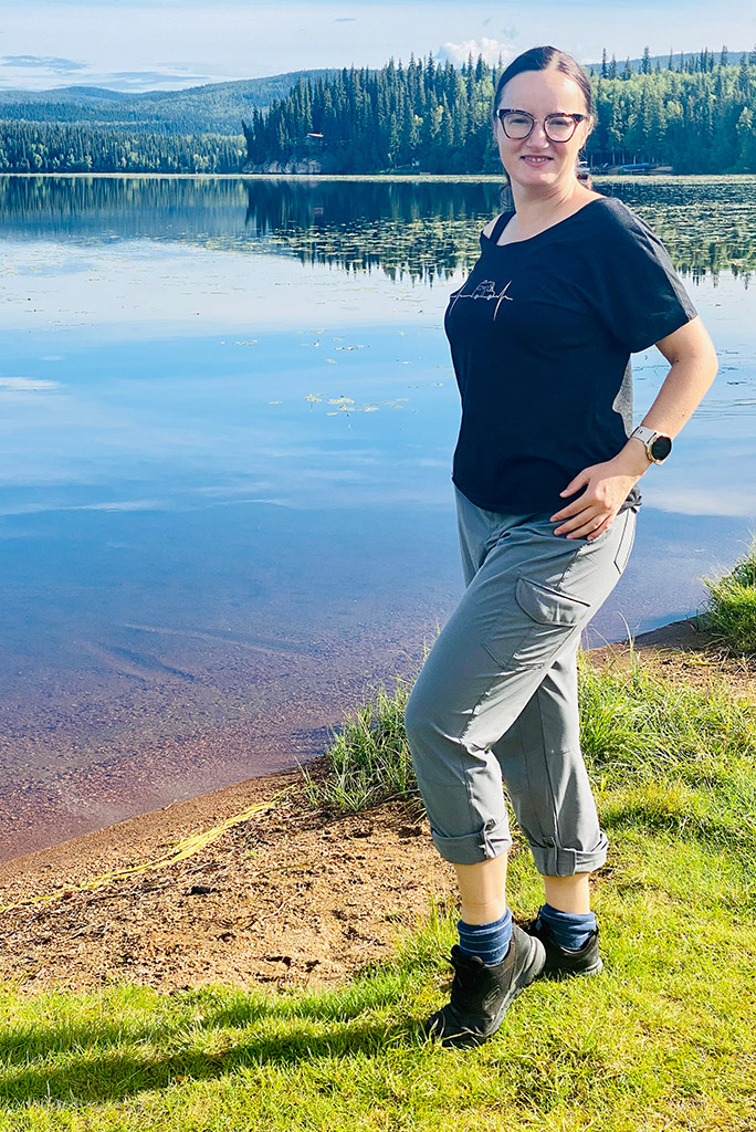 Agnes Stabinska, the author, is standing at the lake in KUHL FREEFLEX ROLL-UP Pants.