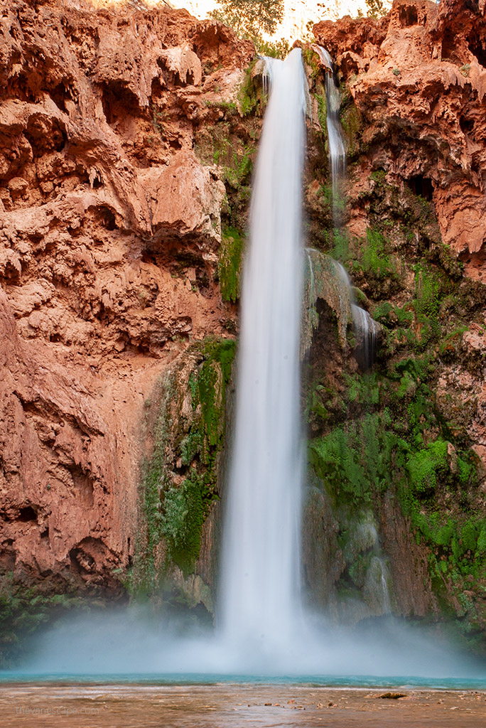 stunning cascade of water on orange rock cliffs at Havasu Falls in Arizona.