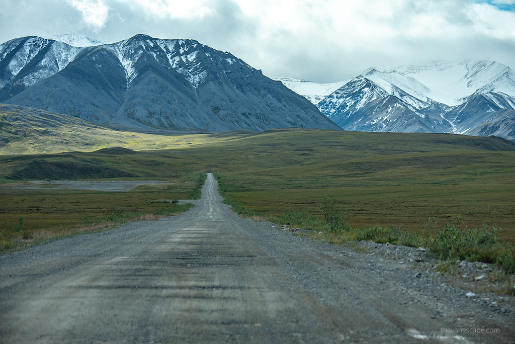 how to plan a road trip: gravel road with stunning mountain view.