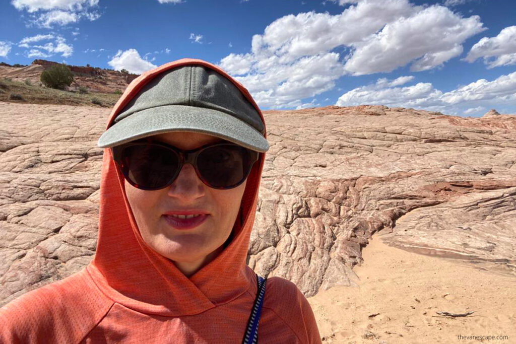 Agnes Stabinska, the author, in orange hoodie with sun protection hiking Zebra Slot Canyon in Utah