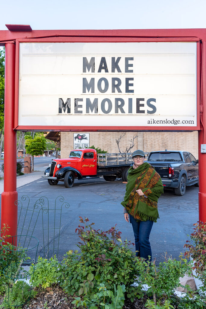 Agnes in Kanab with the sign: Make More Memories.