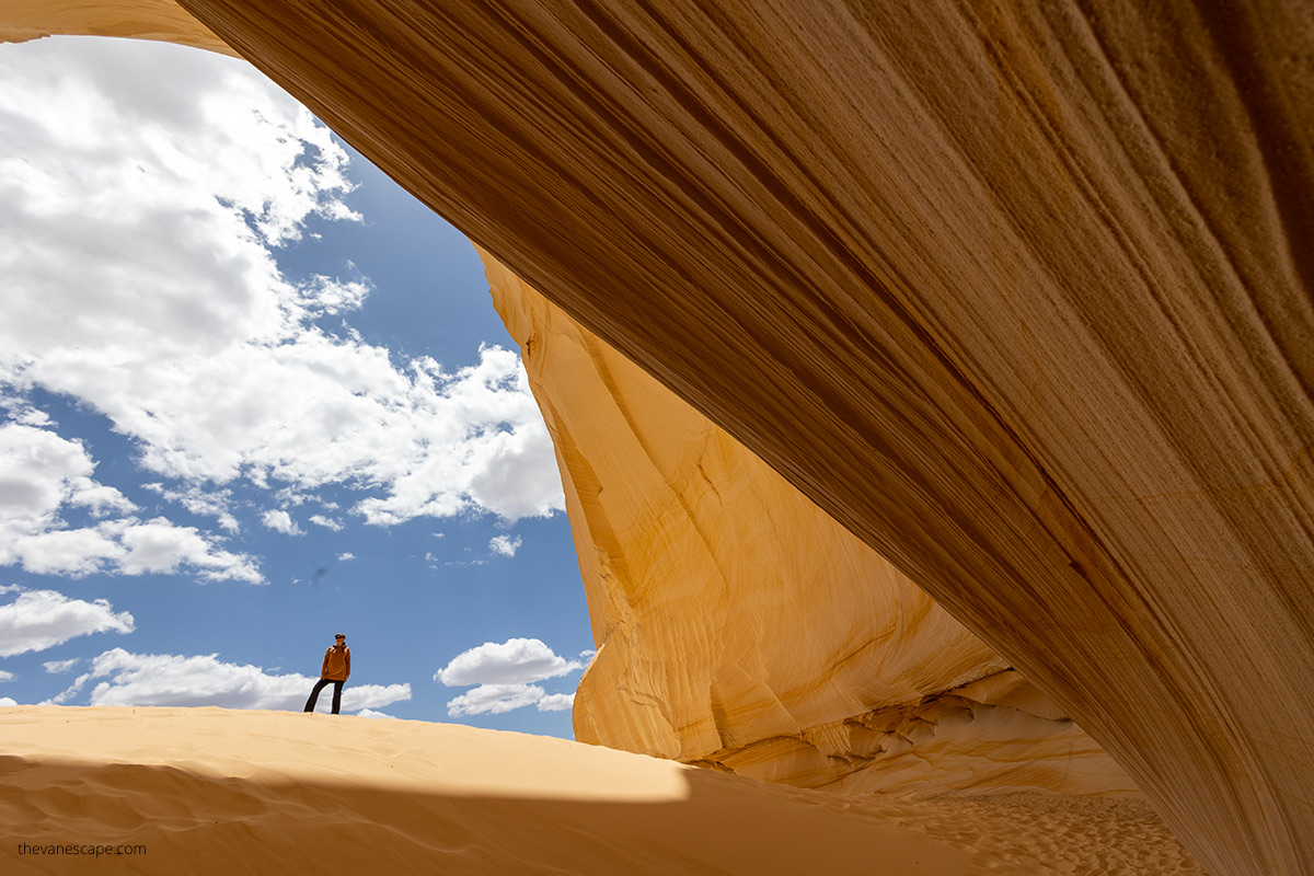 Agnes in Great Chamber Kanab , the walls are yellow and there is a deep sand.